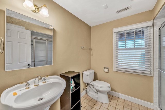 full bathroom featuring toilet, a sink, a shower with door, and visible vents