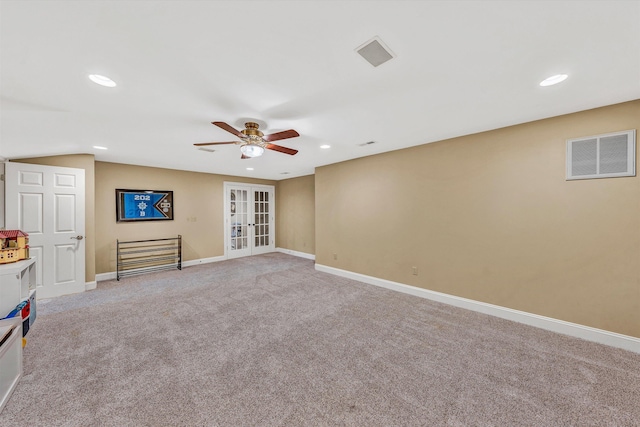 interior space featuring light colored carpet, french doors, baseboards, ceiling fan, and visible vents