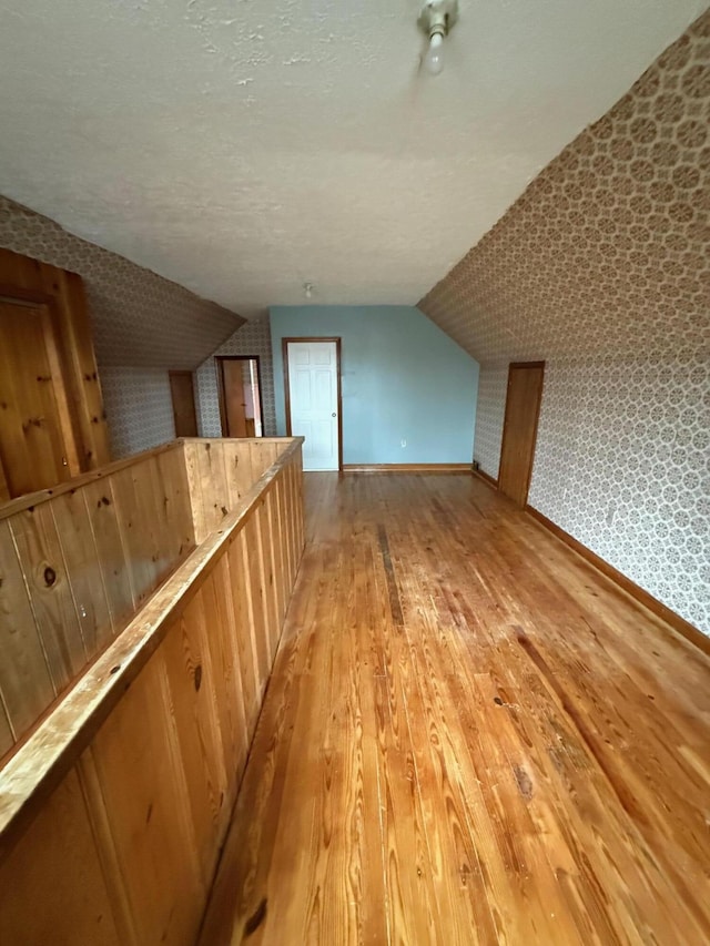 45 Hillcrest Dr, Rocky Mount, VA 24151 - bonus room featuring baseboards, lofted ceiling, a textured ceiling, and light wood-type flooring