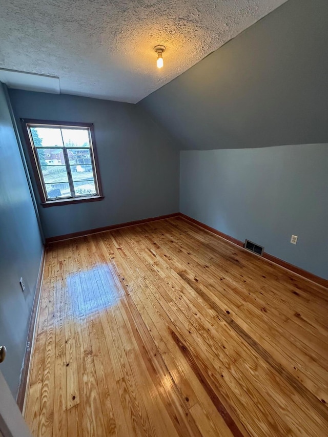 45 Hillcrest Dr, Rocky Mount, VA 24151 - additional living space with lofted ceiling, baseboards, a textured ceiling, hardwood / wood-style flooring, and visible vents