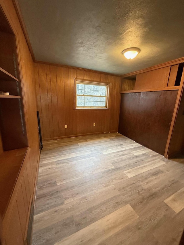 45 Hillcrest Dr, Rocky Mount, VA 24151 - unfurnished bedroom with a closet, a textured ceiling, wood walls, and light wood-type flooring