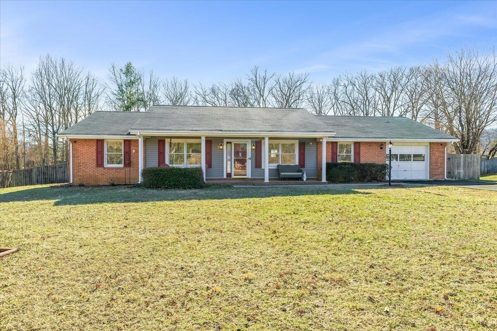 single story home featuring a front yard, a garage, and a porch