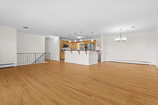 unfurnished living room with a baseboard heating unit, light wood-type flooring, a chandelier, and visible vents