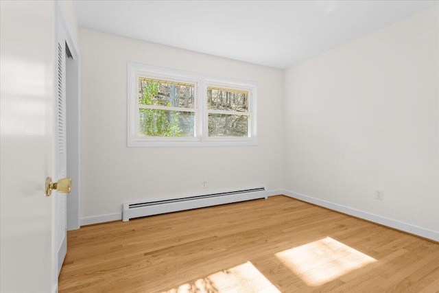 unfurnished bedroom with light wood-style floors, baseboards, a baseboard heating unit, and a closet