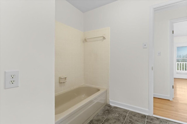 bathroom featuring shower / bath combination and baseboards