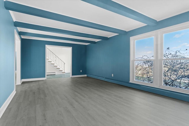 unfurnished room with a baseboard radiator, stairway, wood finished floors, beamed ceiling, and baseboards