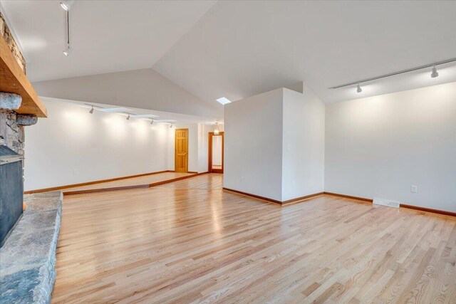 3615 Dogwood Ln SW, Roanoke, VA 24015 - unfurnished living room featuring track lighting, wood finished floors, vaulted ceiling, and baseboards