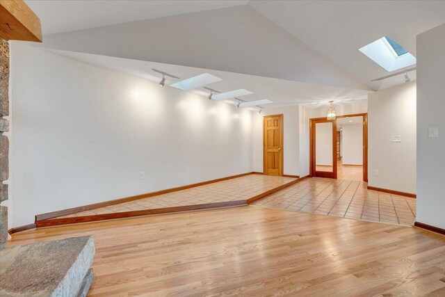 3615 Dogwood Ln SW, Roanoke, VA 24015 - spare room featuring a skylight, wood finished floors, track lighting, baseboards, and high vaulted ceiling
