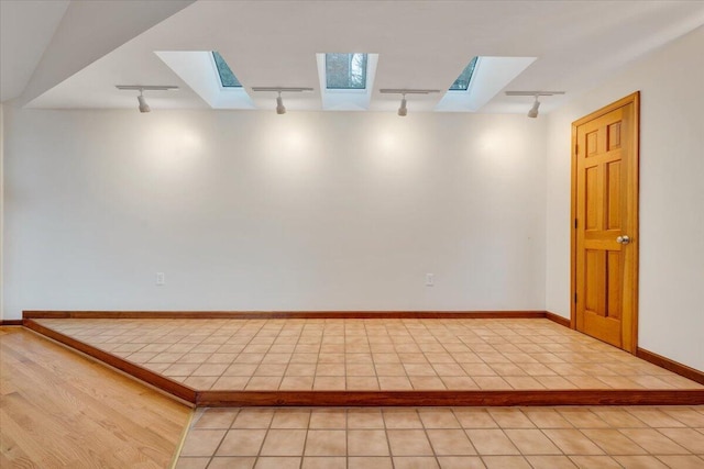3615 Dogwood Ln SW, Roanoke, VA 24015 - empty room featuring track lighting, a skylight, light tile patterned floors, and baseboards