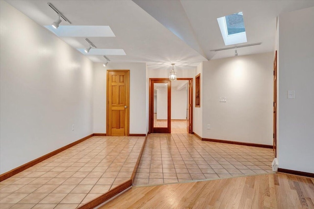 3615 Dogwood Ln SW, Roanoke, VA 24015 - unfurnished room with a skylight, track lighting, baseboards, and light tile patterned floors