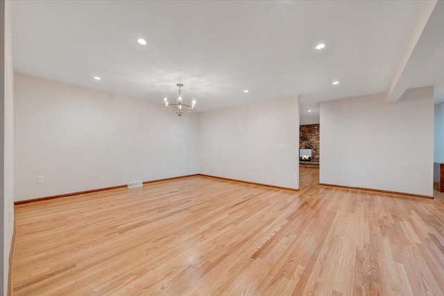 3615 Dogwood Ln SW, Roanoke, VA 24015 - empty room with a chandelier, light wood-style floors, recessed lighting, baseboards, and a stone fireplace