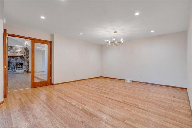 3615 Dogwood Ln SW, Roanoke, VA 24015 - unfurnished room featuring light wood-style flooring, a chandelier, a stone fireplace, baseboards, and recessed lighting