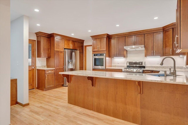 3615 Dogwood Ln SW, Roanoke, VA 24015 - kitchen with appliances with stainless steel finishes, a sink, under cabinet range hood, a peninsula, and brown cabinets