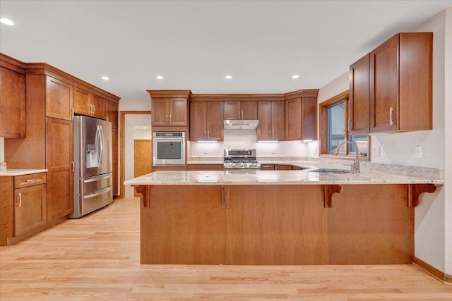 3615 Dogwood Ln SW, Roanoke, VA 24015 - kitchen with stainless steel appliances, under cabinet range hood, a sink, a peninsula, and light wood-type flooring