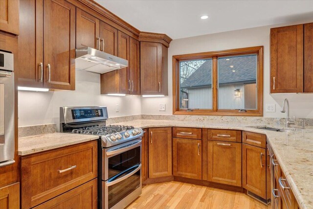3615 Dogwood Ln SW, Roanoke, VA 24015 - kitchen with range with two ovens, a sink, under cabinet range hood, brown cabinets, and light wood-style flooring