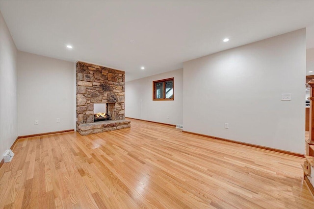 3615 Dogwood Ln SW, Roanoke, VA 24015 - unfurnished living room featuring light wood finished floors, a stone fireplace, baseboards, and recessed lighting