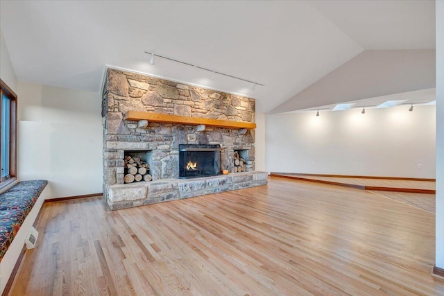 3615 Dogwood Ln SW, Roanoke, VA 24015 - unfurnished living room featuring rail lighting, vaulted ceiling, wood finished floors, a fireplace, and baseboards