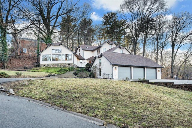 3615 Dogwood Ln SW, Roanoke, VA 24015 - view of property exterior with a lawn, a garage, stucco siding, and a shingled roof
