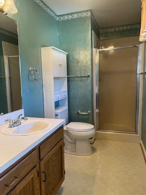 bathroom with vanity, toilet, and an enclosed shower