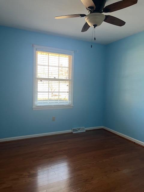 unfurnished room with dark hardwood / wood-style floors and ceiling fan