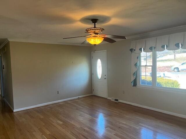 foyer entrance with ornamental molding, hardwood / wood-style floors, and ceiling fan