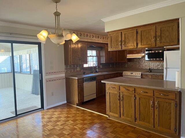 kitchen with pendant lighting, white appliances, dark parquet flooring, and crown molding