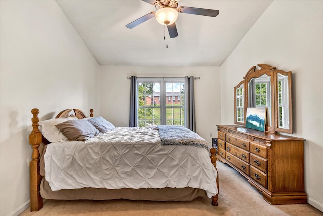 carpeted bedroom with multiple windows, vaulted ceiling, and ceiling fan