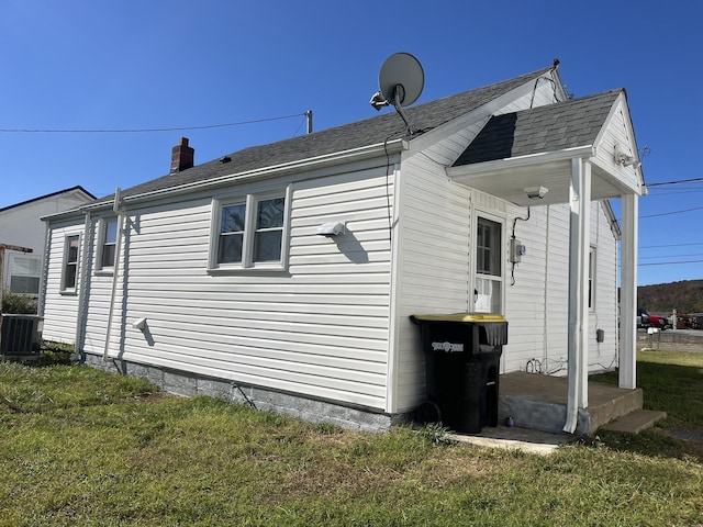 view of side of property with cooling unit and a lawn