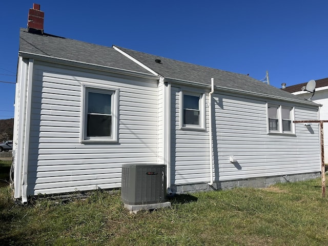 view of side of home with cooling unit and a yard