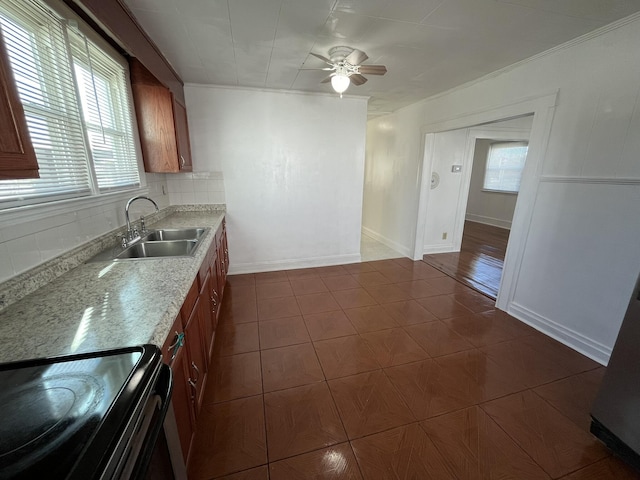 kitchen with tasteful backsplash, light stone counters, ceiling fan, black / electric stove, and sink