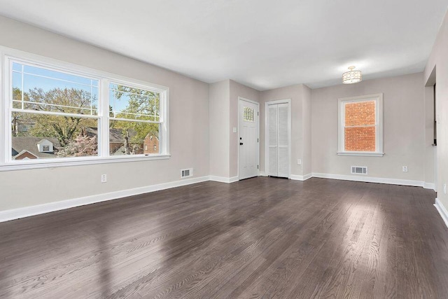 unfurnished living room with dark wood-type flooring