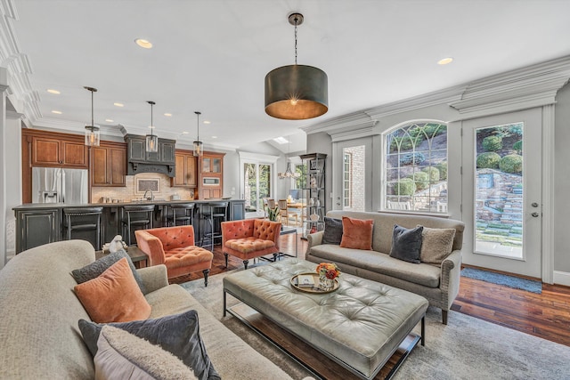 living area with recessed lighting, light wood-type flooring, baseboards, and ornamental molding