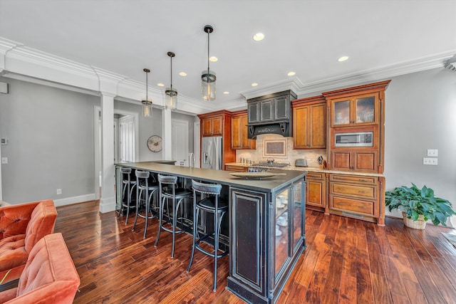 kitchen featuring a kitchen bar, backsplash, dark wood-style floors, appliances with stainless steel finishes, and brown cabinetry