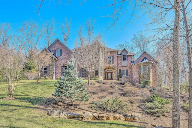 view of front of property featuring brick siding and a front yard