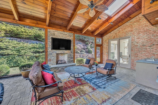 view of patio / terrace with an outdoor living space with a fireplace and a ceiling fan