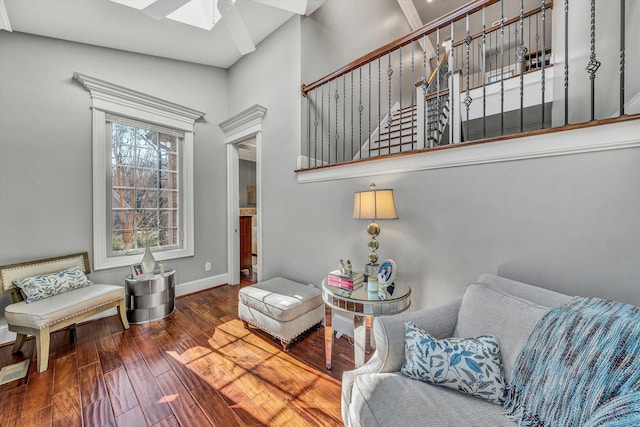 living area featuring a skylight, baseboards, and wood-type flooring