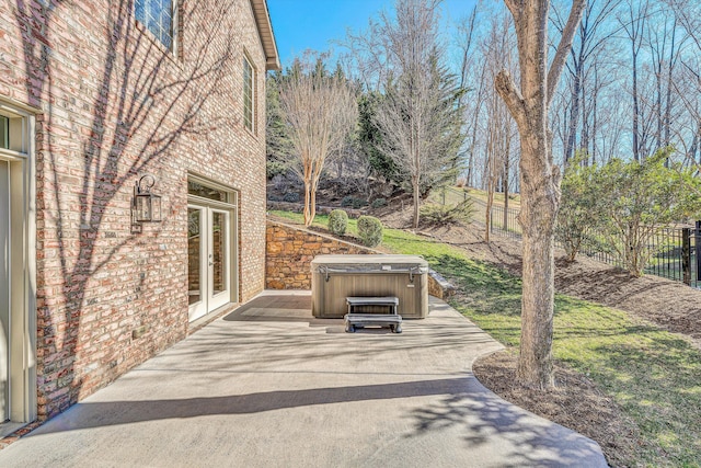 view of patio / terrace with fence, french doors, and a hot tub