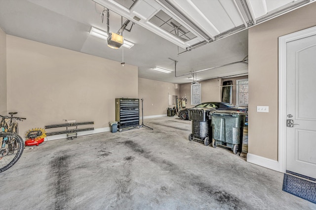 garage with baseboards and a garage door opener