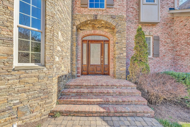 entrance to property with brick siding and stone siding