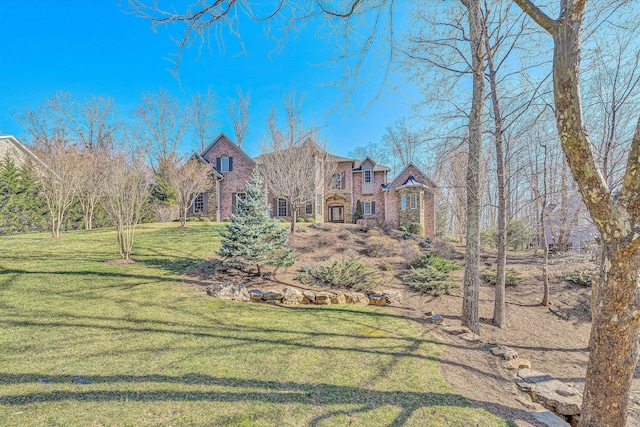 view of front of home featuring a front yard and brick siding