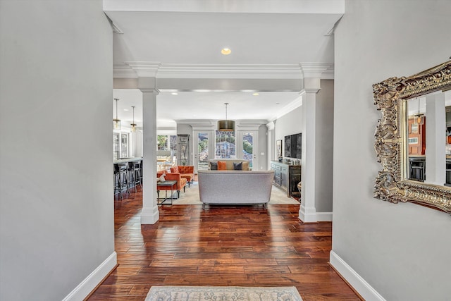 hall featuring hardwood / wood-style floors, baseboards, and decorative columns