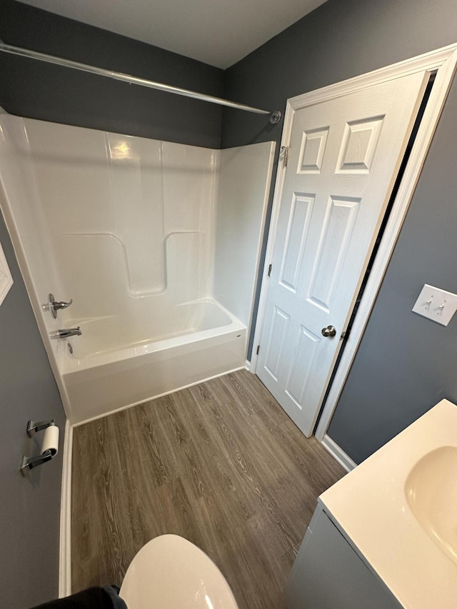 full bathroom with hardwood / wood-style floors, toilet, vanity, and shower / tub combination