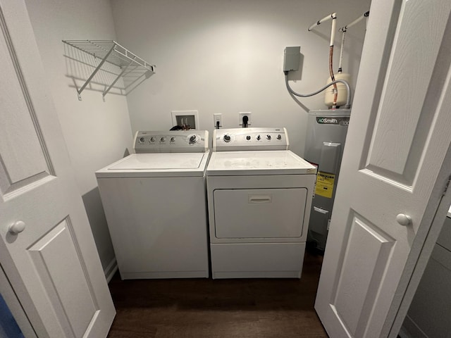 washroom with water heater, dark hardwood / wood-style flooring, and washer and clothes dryer