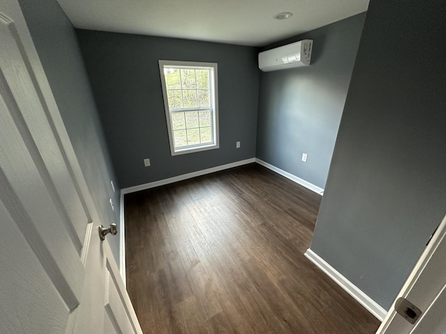 empty room with dark hardwood / wood-style floors and a wall mounted air conditioner