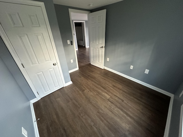 unfurnished bedroom with dark hardwood / wood-style floors