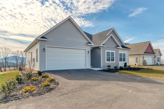 ranch-style house with aphalt driveway, cooling unit, board and batten siding, and a garage