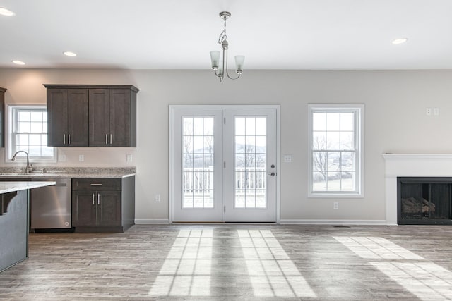 kitchen featuring light wood-type flooring, a sink, stainless steel dishwasher, recessed lighting, and dark brown cabinetry