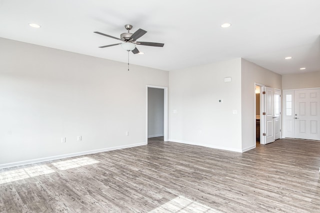 empty room with recessed lighting, baseboards, and wood finished floors