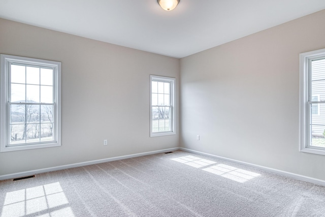 carpeted empty room with visible vents and baseboards