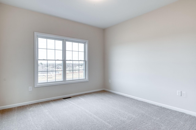 empty room with visible vents, carpet floors, and baseboards